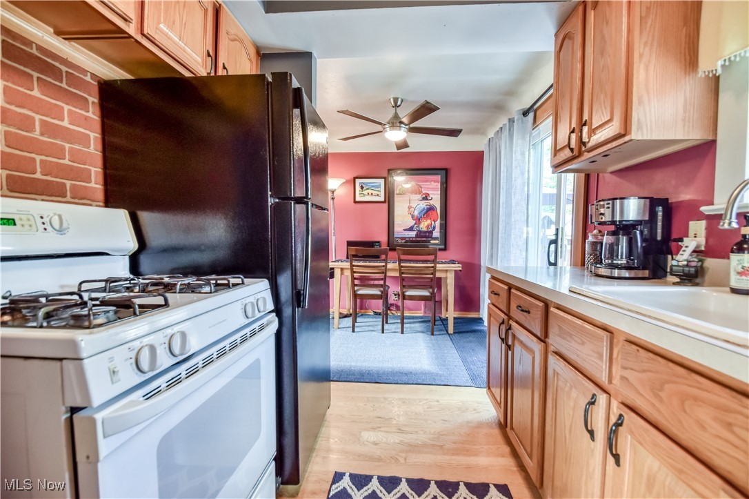 357 Clarmont Road Willowick, OH 44095 - Photo 8 of 27 Kitchen with gas range gas stove, light countertops, light wood-type flooring, and ceiling fan