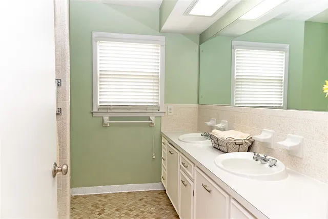 a bathroom with a sink a toilet and a window