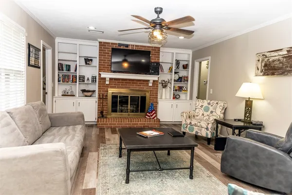a living room with furniture a fireplace and a flat screen tv
