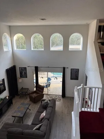 a living room with couches floor and a flat screen tv