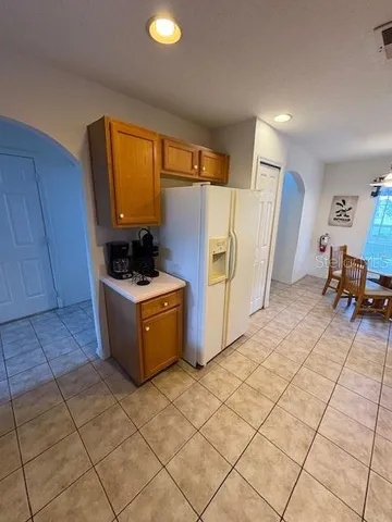 a kitchen with a sink a refrigerator and wooden cabinets