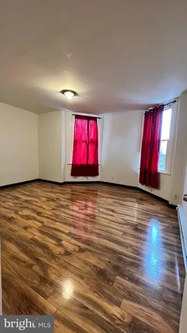 a view of an empty room with window and stairs
