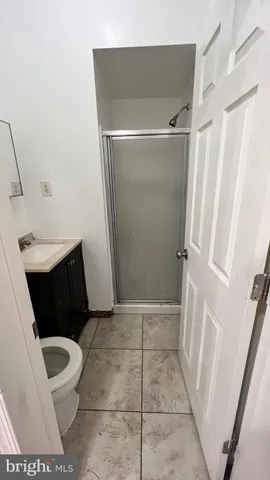 a bathroom with a sink a toilet a shower and a window
