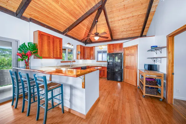 a kitchen with stainless steel appliances granite countertop a kitchen island a stove a sink and a wooden floors