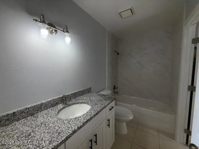 a bathroom with a granite countertop sink a toilet and shower