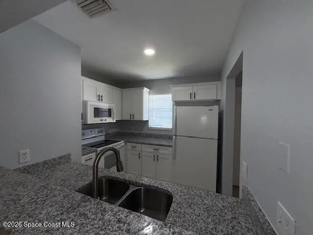 a kitchen with stainless steel appliances granite countertop a sink a refrigerator and a granite counter tops