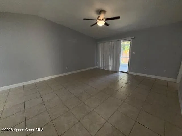 an empty room with windows and chandelier fan