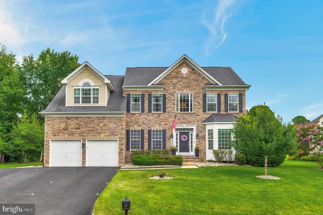 a front view of a house with a garden and yard