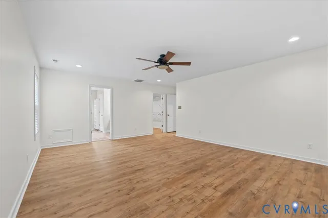 wooden floor in an empty room with a ceiling fan
