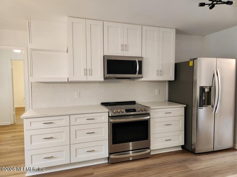 1424 Panther Run Road Jacksonville, FL 32225 - Photo 18 of 36 a kitchen with stainless steel appliances white cabinets and a refrigerator