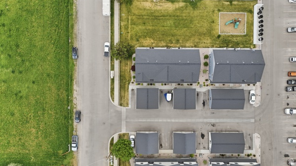 391 South 440th Street West Preston, ID 83263 - Photo 23 of 28 Aerial perspective highlighting multi-unit residential properties with dark shingle roofs, individual garages, and paved driveways