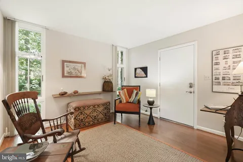 a living room with furniture a flat screen tv and kitchen view