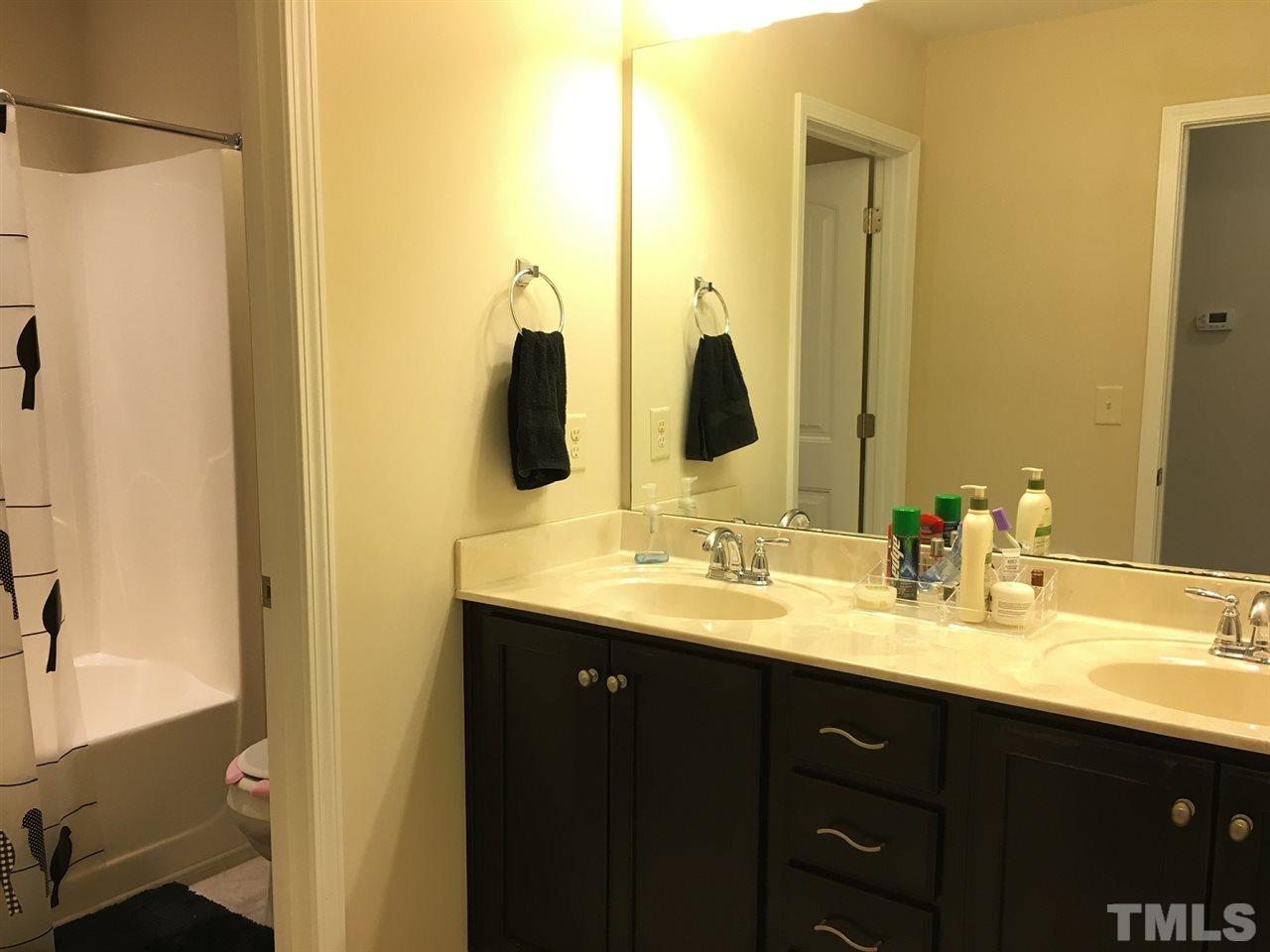 2423 Swans Rest Way Raleigh, NC 27606 - Photo 17 of 25 a bathroom with a double vanity sink and a mirror