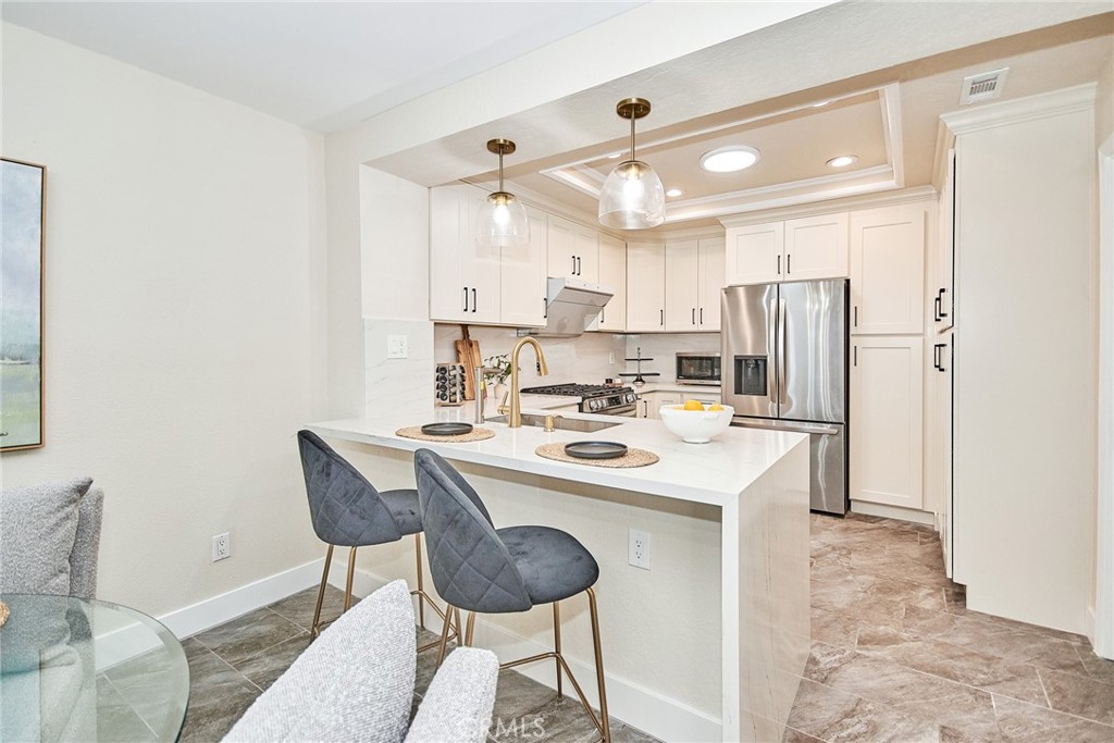 950 South Rim Crest Drive Anaheim Hills, CA 92807 - Photo 14 of 40 a kitchen with stainless steel appliances a table and chairs