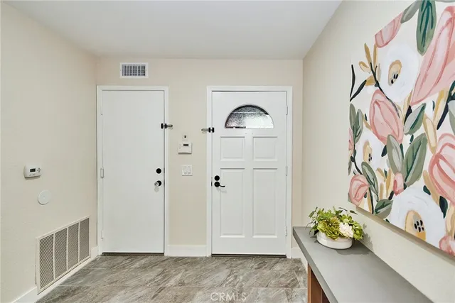 a view of an entryway with paintings on the wall
