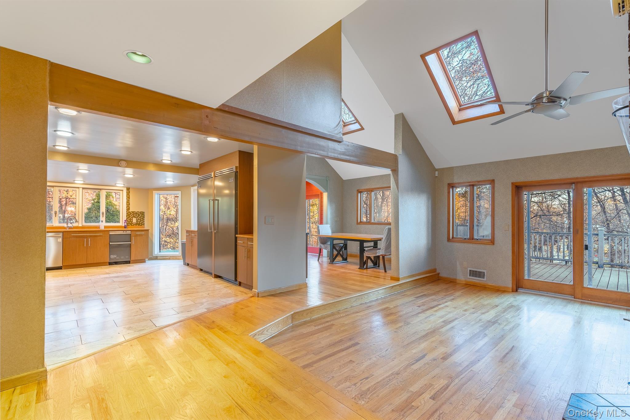 22 Weyant Road Fort Montgomery, NY 10922 - Photo 7 of 26 Unfurnished living room featuring light wood-type flooring, high vaulted ceiling, ceiling fan, and a skylight