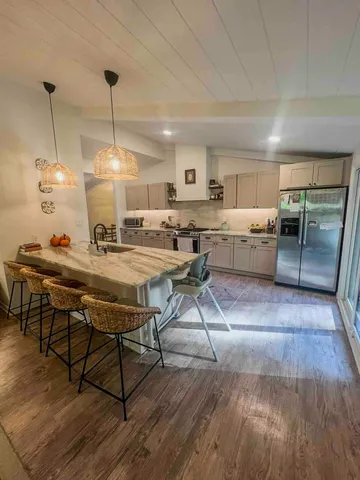 a kitchen with a table chairs stove and wooden floor
