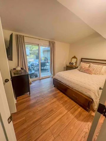 a bedroom with a bed and wooden floor