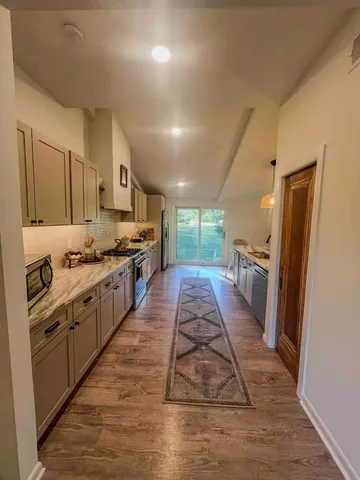 a large kitchen with stainless steel appliances kitchen island granite countertop a large stove top oven a sink dishwasher and a refrigerator