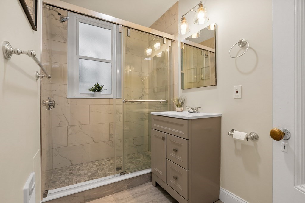 481 Beacon Street, Unit 43 Boston, MA 02115 - Photo 7 of 10 a bathroom with a shower sink and mirror