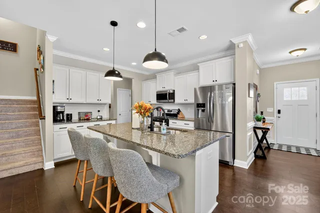 a kitchen with refrigerator cabinets dining table and chairs