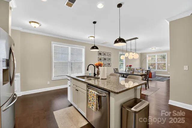 a kitchen with stainless steel appliances granite countertop a stove a sink and a refrigerator