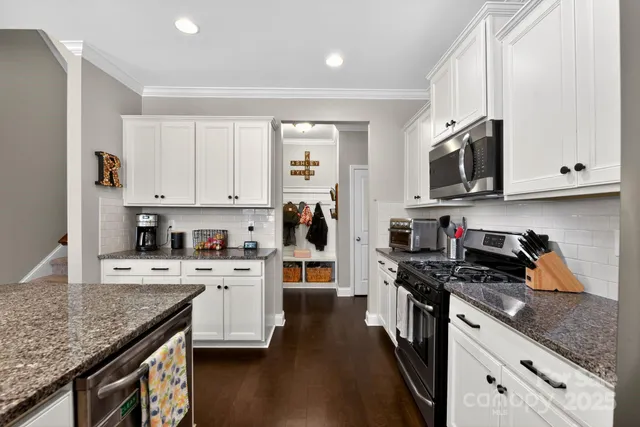 a kitchen with stainless steel appliances granite countertop a stove sink and cabinets
