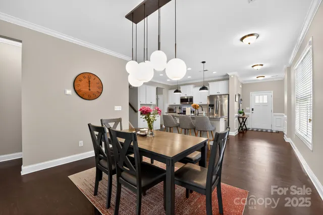 a view of a dining room and a kitchen with a table and chairs