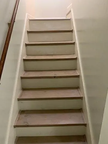 a view of a hallway with wooden floor and chandelier