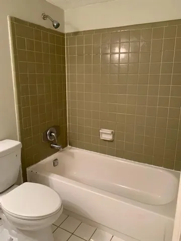 a white bath tub sitting next to a white toilet and a sink