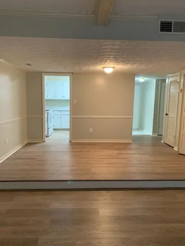 a view of a hallway with wooden floor and chandelier