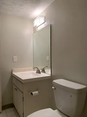 a bathroom with a sink toilet and mirror
