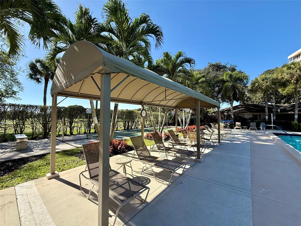 3520 Oaks Way, Unit 306 Pompano Beach, FL 33069 - Photo 12 of 18 a view of patio with swimming pool table and chairs
