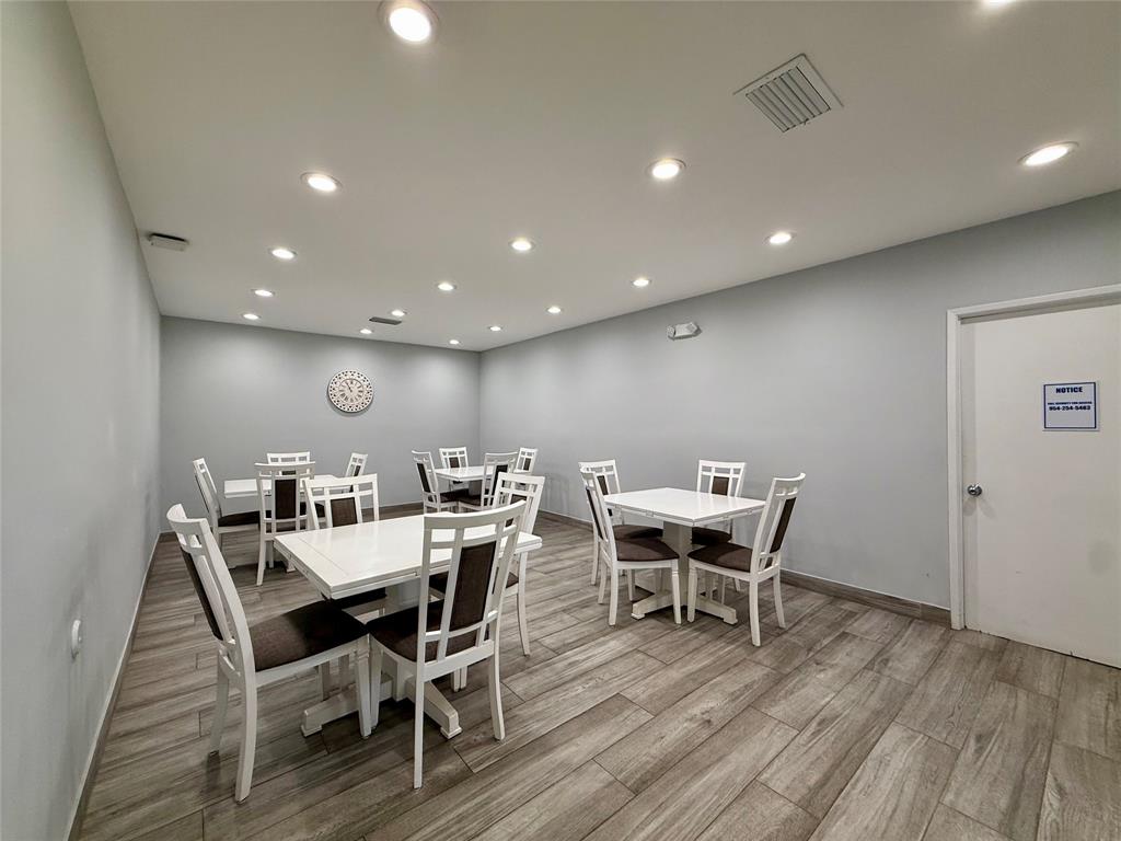 3520 Oaks Way, Unit 306 Pompano Beach, FL 33069 - Photo 15 of 18 a view of a dining room with furniture wooden floor and chandelier