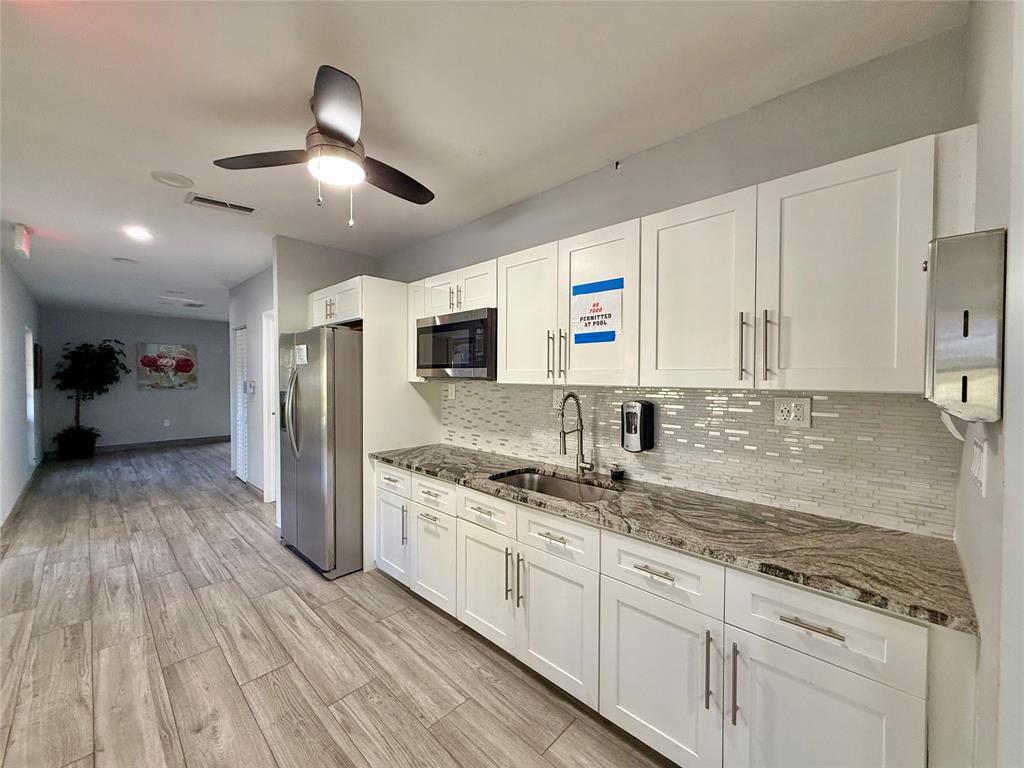 3520 Oaks Way, Unit 306 Pompano Beach, FL 33069 - Photo 16 of 18 a kitchen with stainless steel appliances granite countertop a sink refrigerator and cabinets