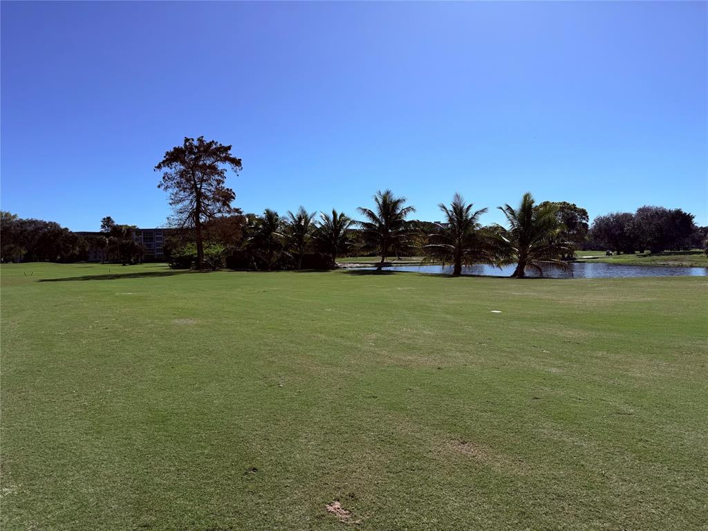 3520 Oaks Way, Unit 306 Pompano Beach, FL 33069 - Photo 17 of 18 a view of a field with an trees in the background