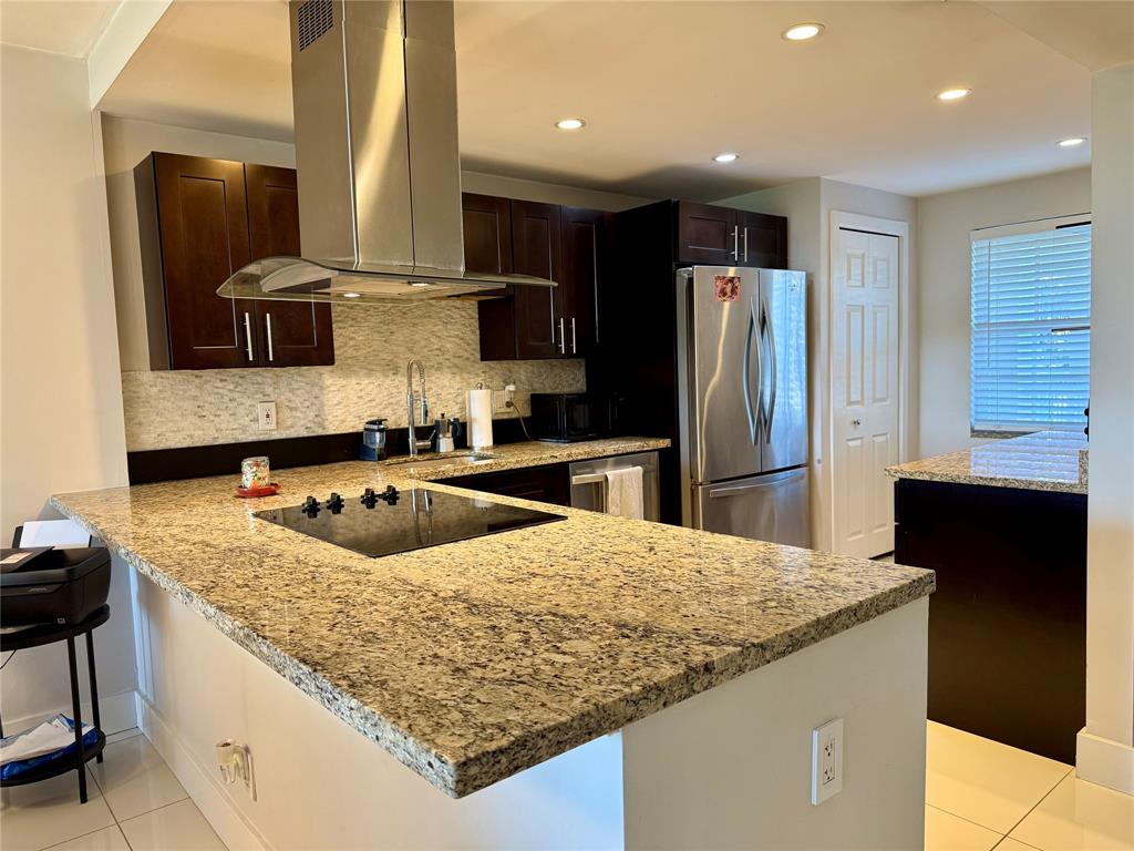 3520 Oaks Way, Unit 306 Pompano Beach, FL 33069 - Photo 7 of 18 a kitchen with stainless steel appliances granite countertop a sink and a refrigerator
