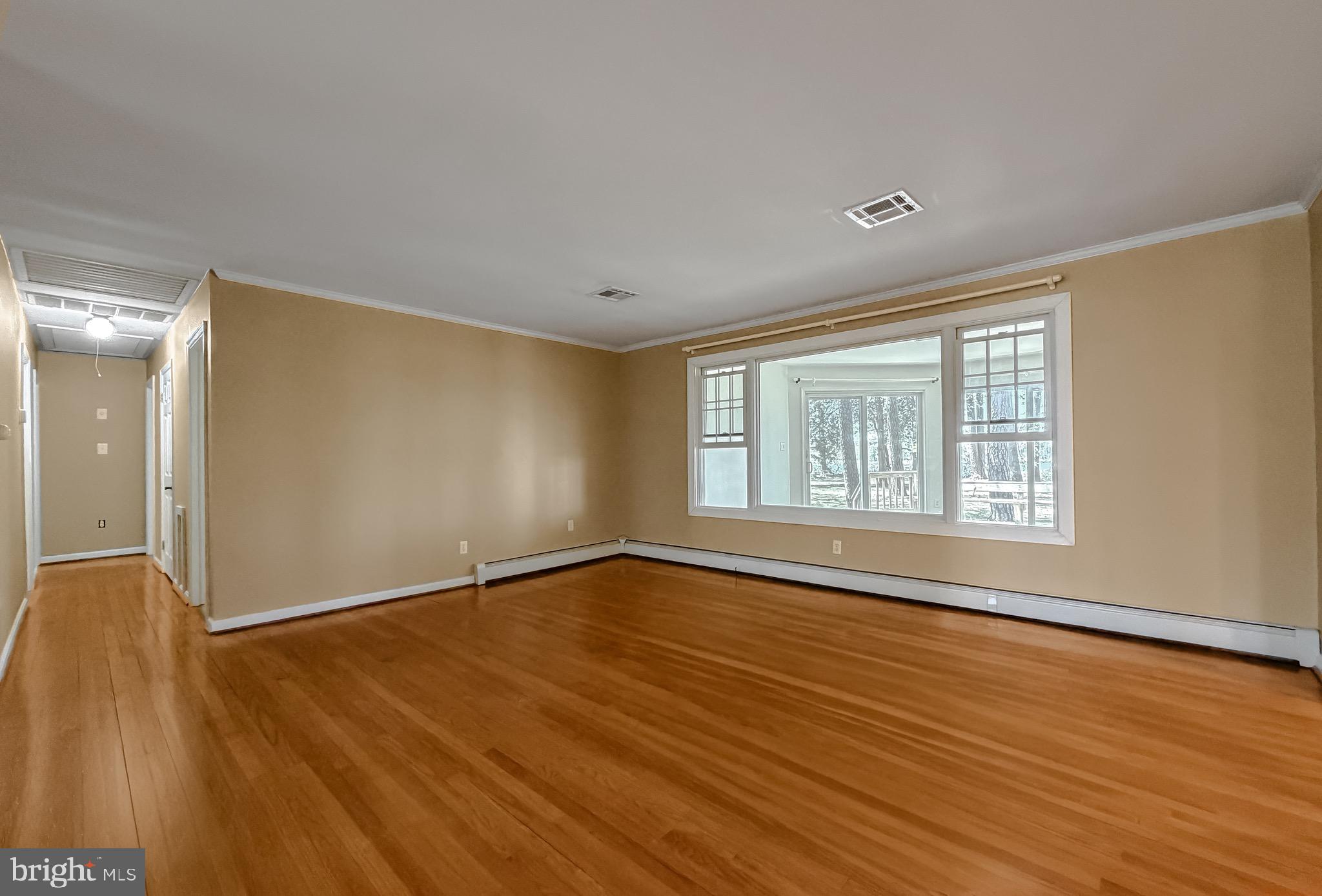 19479 North Snow Hill Manor Road Lexington Park, MD 20653 - Photo 21 of 34 a view of an empty room with wooden floor and a window