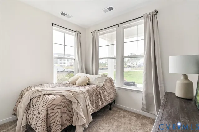 a bed sitting in a bedroom next to a window