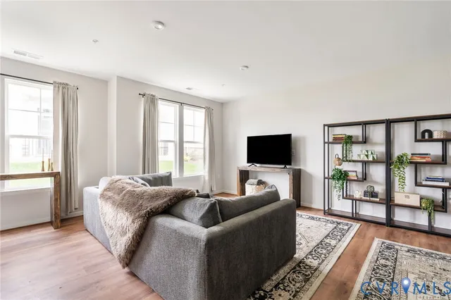 a living room with furniture a flat screen tv and a rug