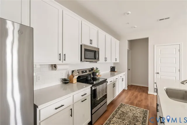 a kitchen with stainless steel appliances a stove a sink and a refrigerator