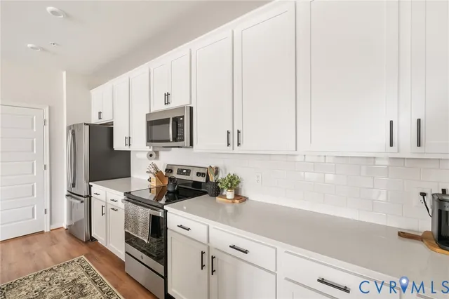 a kitchen with stainless steel appliances white cabinets and a sink