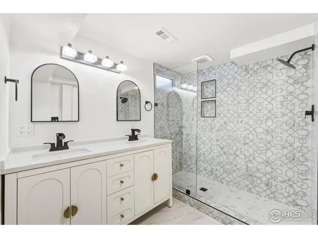 a bathroom with a double vanity sink mirror and shower