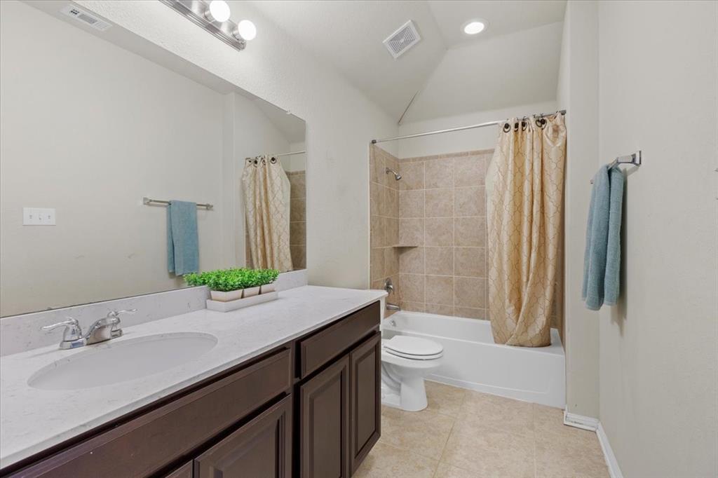 11306 Runnel Ridge Road Manor, TX 78653 - Photo 25 of 26 a bathroom with a granite countertop sink toilet and shower