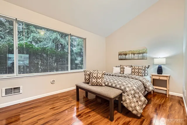 a bedroom with a bed and a wooden floor