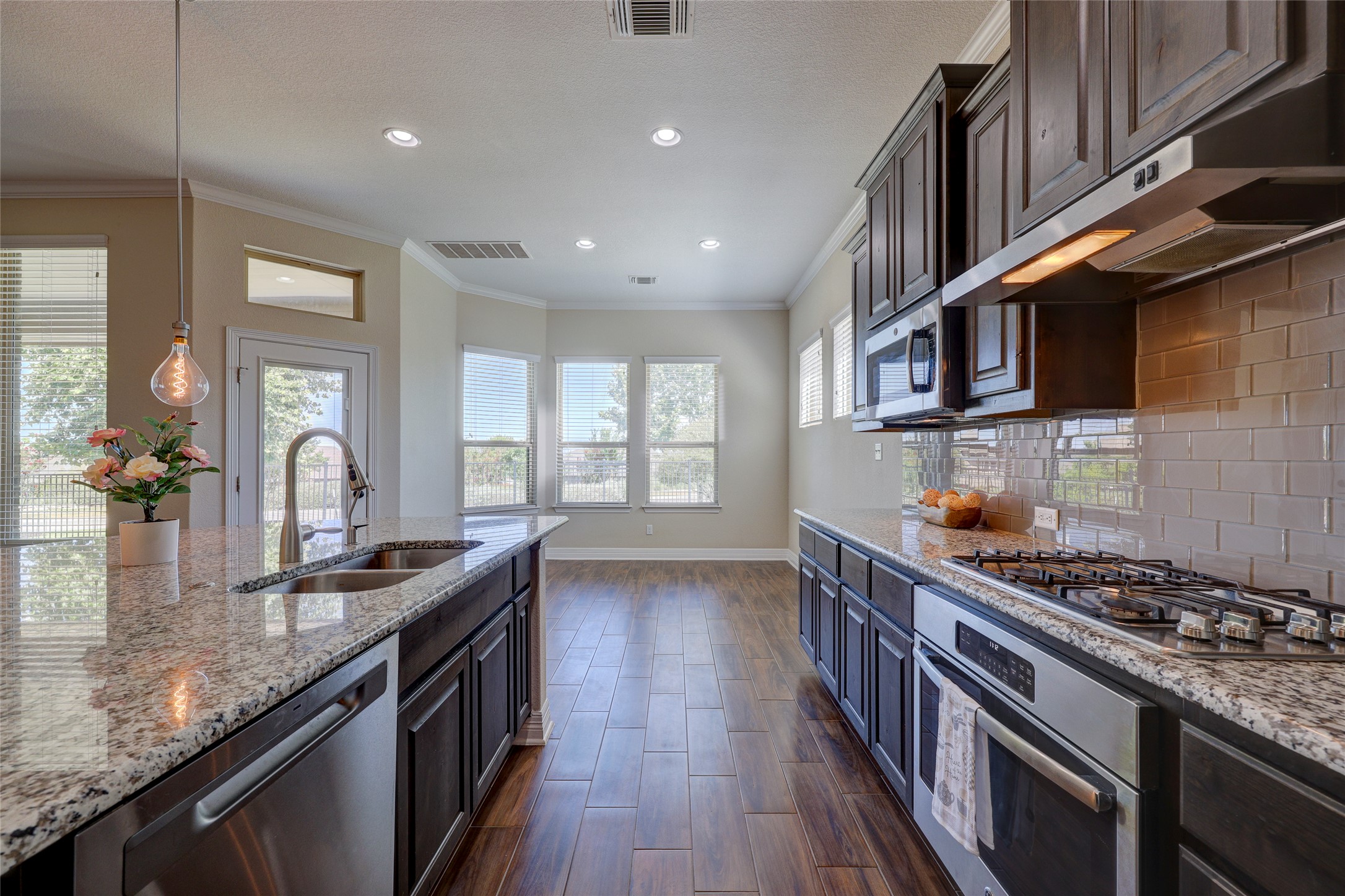 409 Betony Loop Buda, TX 78610 - Photo 8 of 38 An inviting kitchen with rich cabinetry, lustrous granite counters, and integrated appliances.