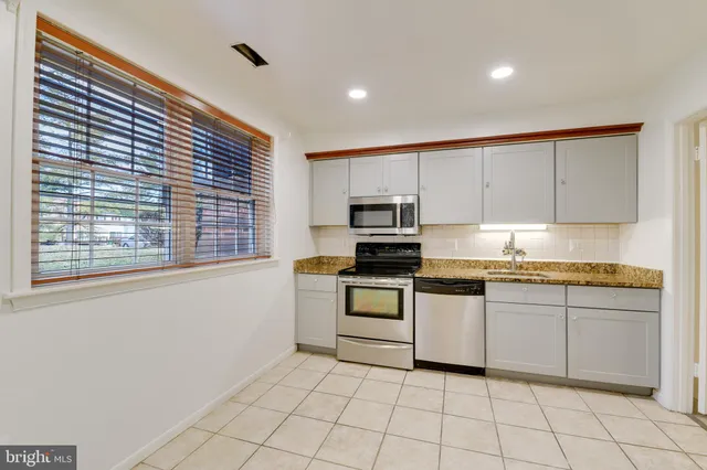 a kitchen with white cabinets a sink and white appliances