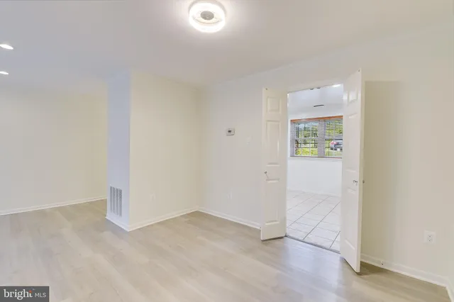 an empty room with wooden floor and a window