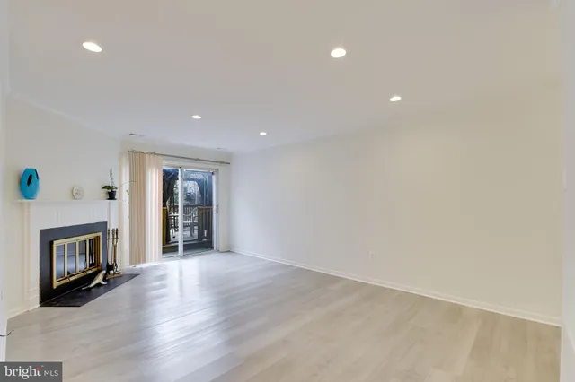 a view of an empty room with a fireplace and a window