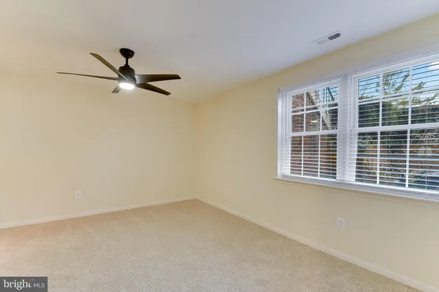 a view of a room with a ceiling fan and a window